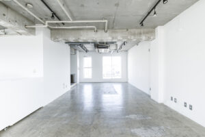 スケルトン仕様の天井と白壁、味のあるモルタルの組み合わせが印象的なアパレル展示会場