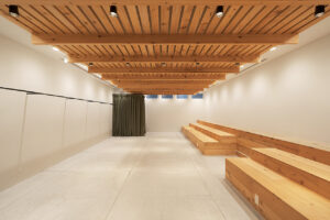 ナチュラルウッドの天井と白壁のアパレル展示会場