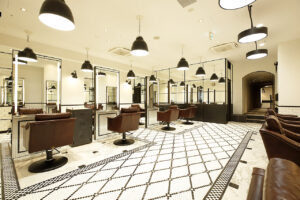 MINX ginza central : 銀座にある美容室レンタルスタジオ、天井から吊るされた照明、皮製のソファ、黒と白を基調とした室内