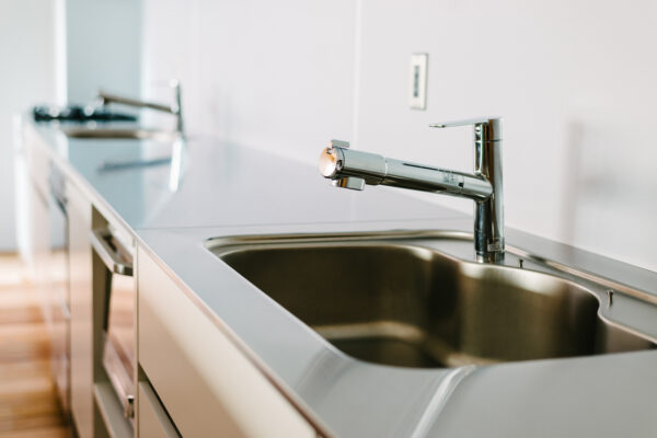 Modern kitchen sink with a shiny chrome faucet and stainless steel countertop.