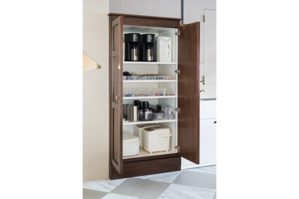 2017_0303_0069 Tall wooden kitchen cabinet with open doors, shelves holding coffee makers, containers, and small appliances