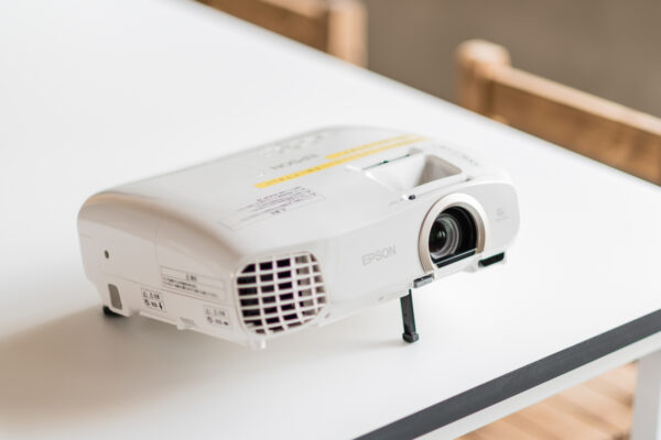 2017_0303_0072 White Epson projector on a white table, lens visible and ready to project.