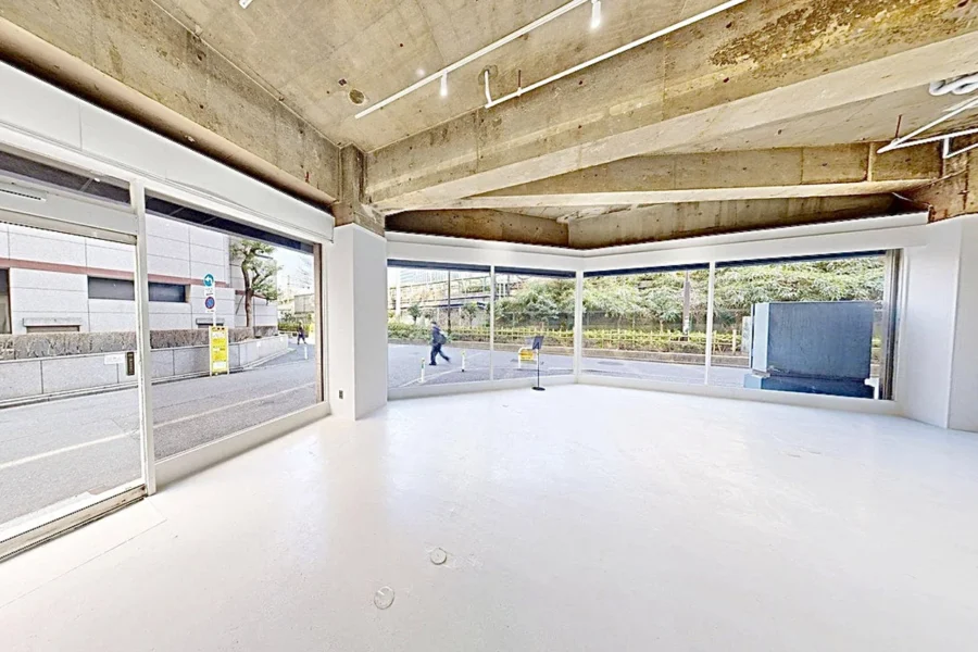 Stella-Gallery-Shinjuku-03302026_223151-2-1 Bright empty storefront/studio with white floor and large glass walls facing the street outside.